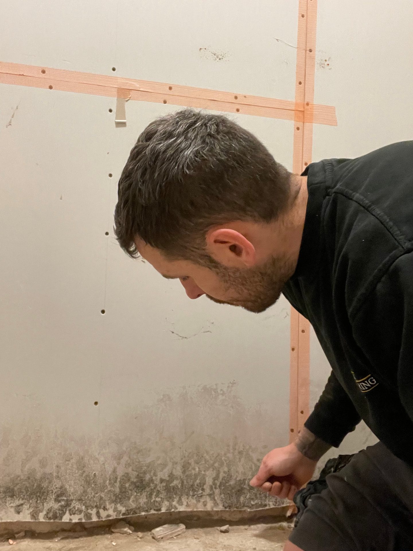 Black spot mould forming on a cold internal wall behind furniture
